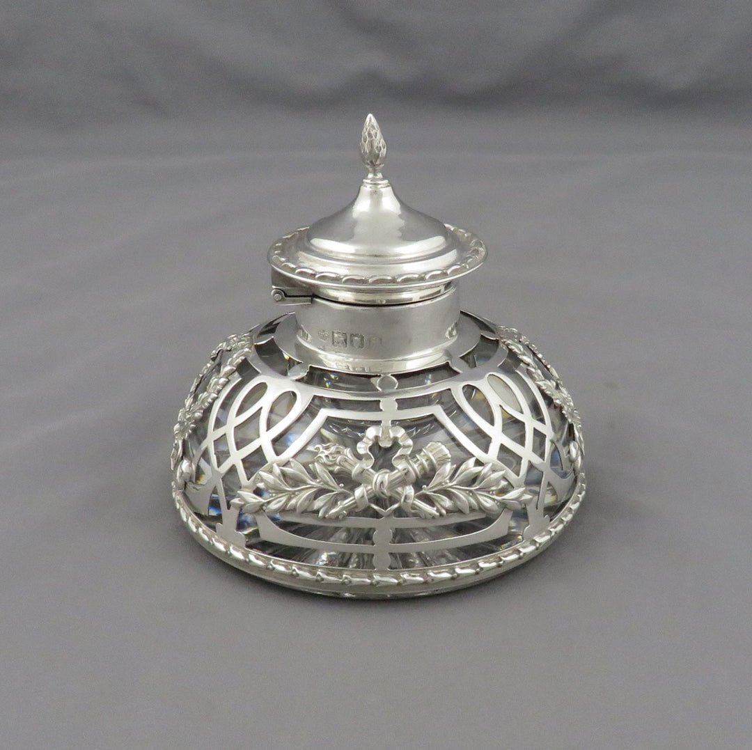An Edwardian sterling silver filigree ink bottle with a decorative lid