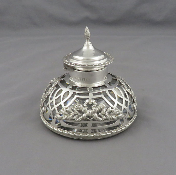 An Edwardian sterling silver filigree ink bottle with a decorative lid